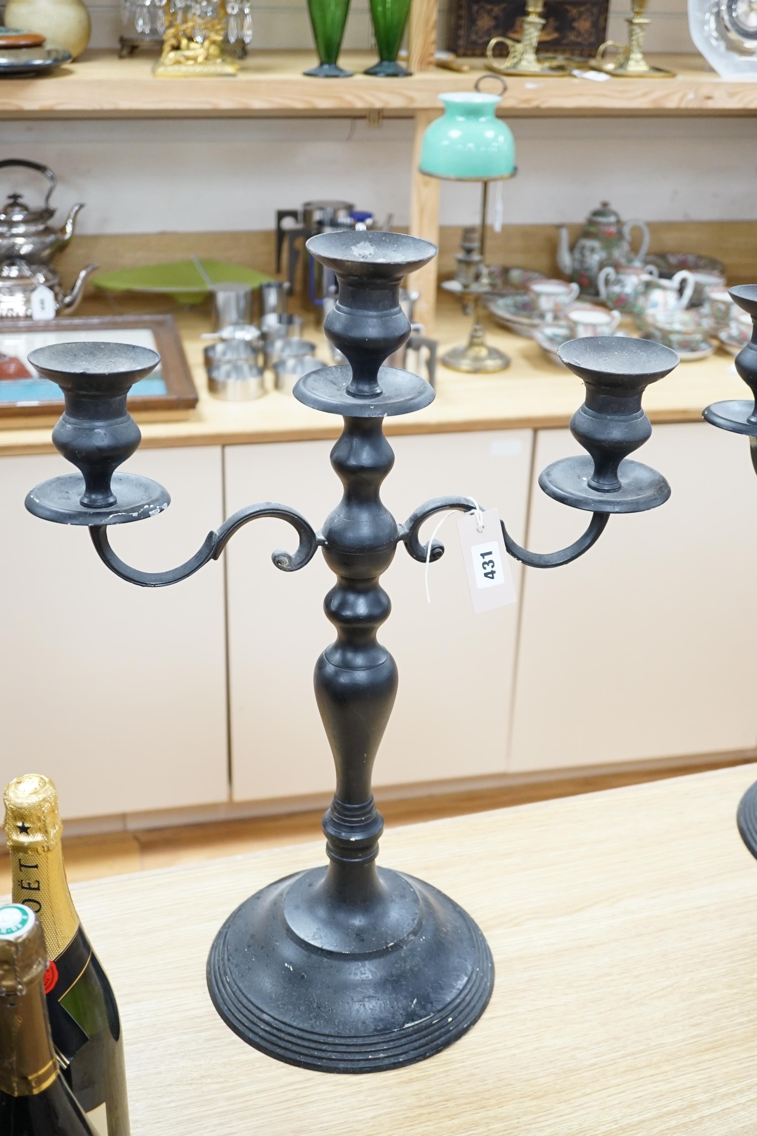 A pair of metal three branch candelabra, 60cm high